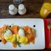 Boiled eggs, a salmon fillet, lentils, and almonds arranged on a wooden kitchen table